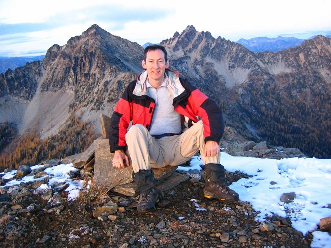 I took another picture sitting on the summit cairn.
Now I needed to get off the mountain.  I descended as fast as I could in the failing light, 
and managed to make it to the meadows below the rock outcrops before I had to use my headlamp.
In the scrubby trees and rocks, I couldn't see the crest above me, but I managed to ascend in just the right spot to hit the pass.
Then it was just a jog down the trail to camp at 8pm, where Richard & Lynn had just started heading up to look for me.